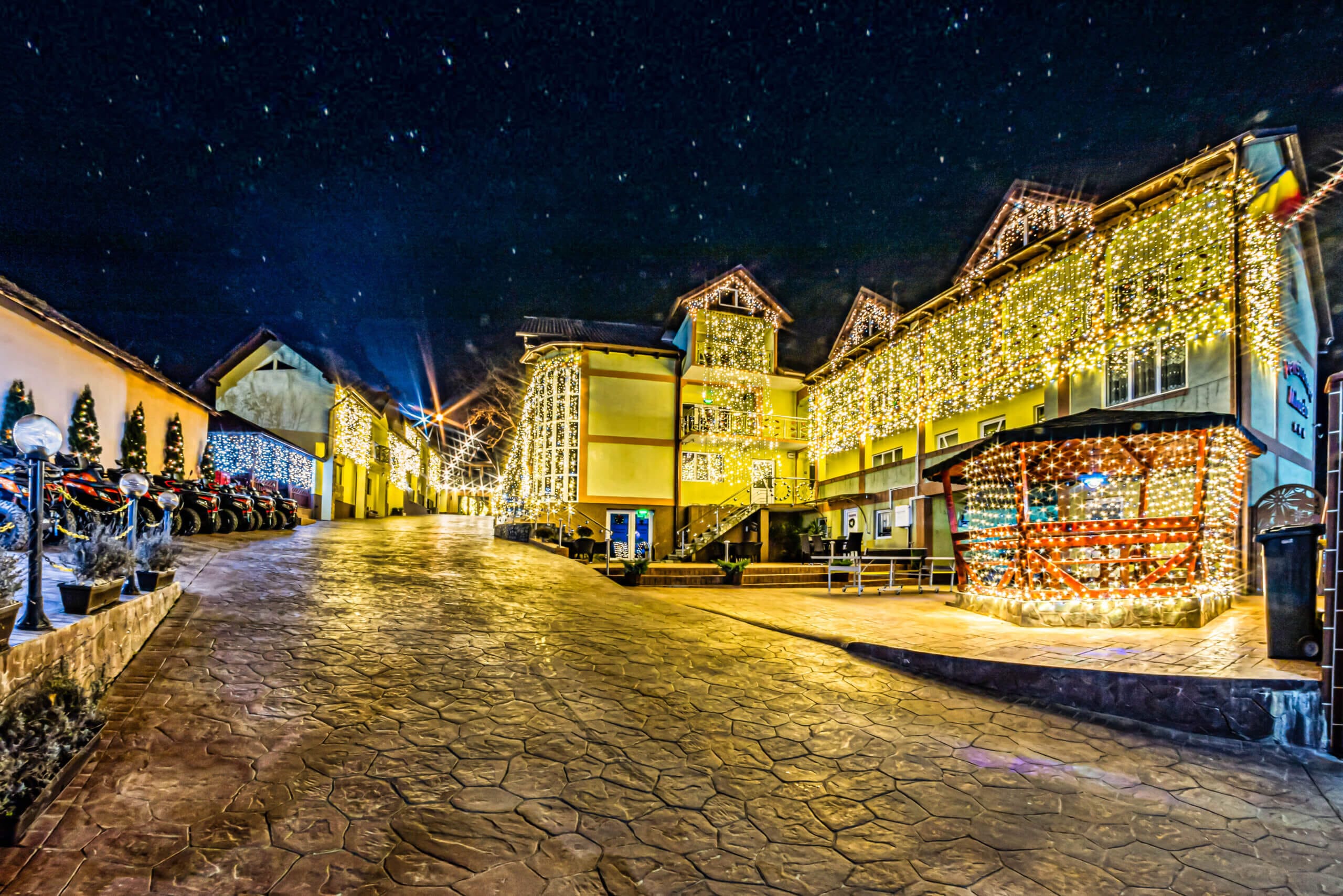 Stradă luminată de sărbători, clădiri decorate festiv