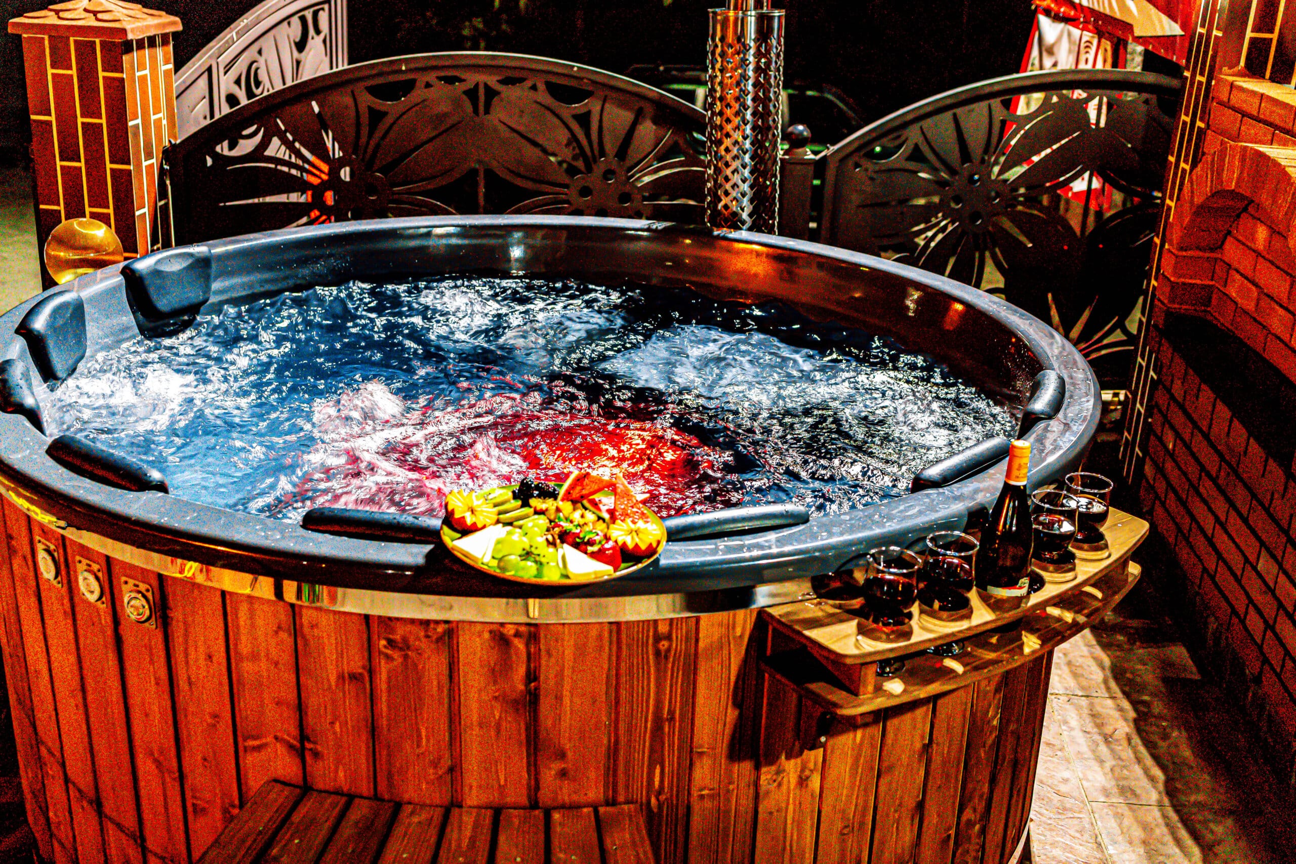 Jacuzzi cu fructe și băuturi, atmosferă relaxantă.