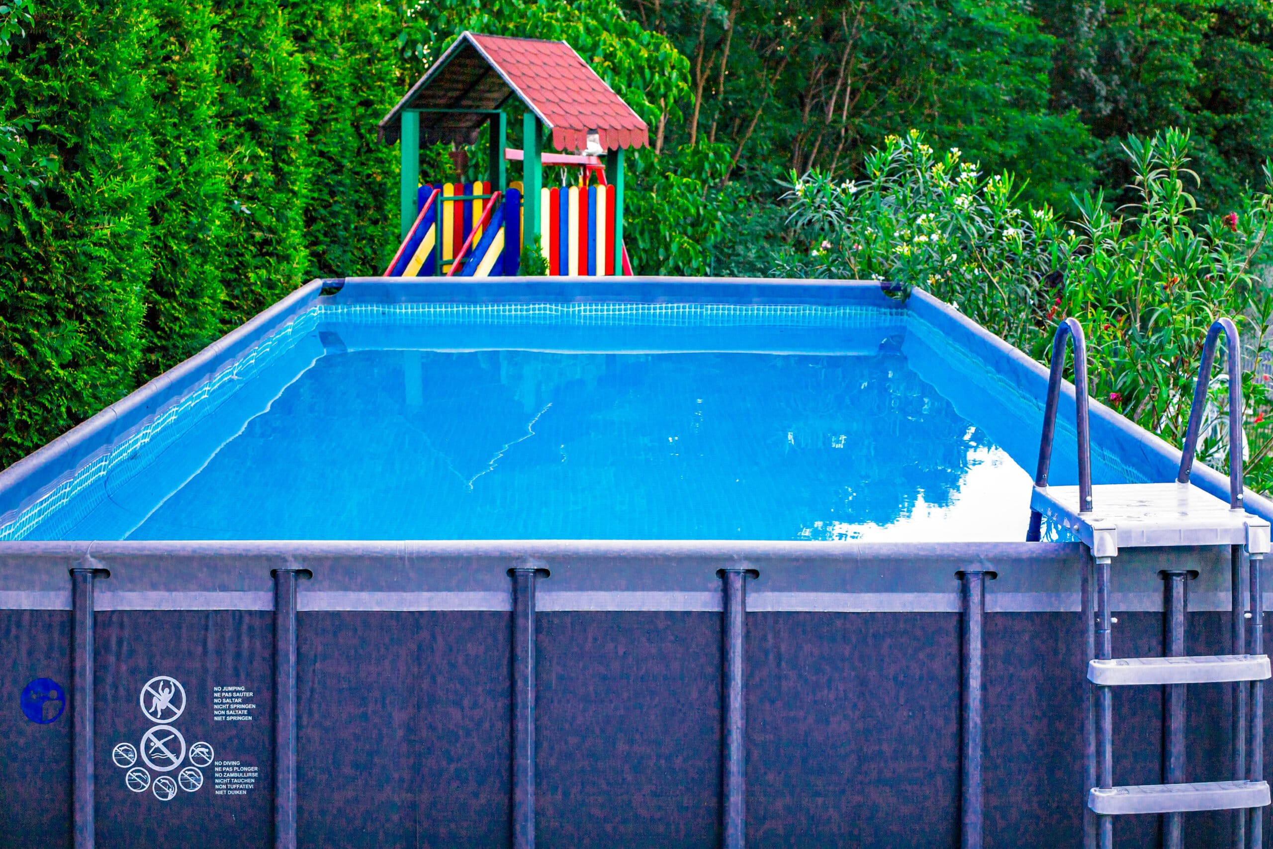 Piscină dreptunghiulară cu tobogan colorat în grădină.